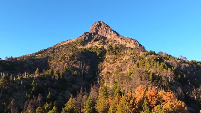Nevado de Colima mountain summit, Mexico, reaching a clear blue sky in aerial approaching view