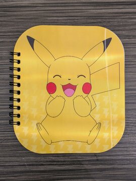 Vista de cerca de una libreta con portada con Pikachu de Pok&eacute;mon, colocada encima de una mesa de madera, en Madrid, Espa&ntilde;a, 11 de abril de 2026