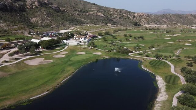 Orbiting around an artificial lake and the Font del Llop golf club building. Monforte del Cid, Spain.
