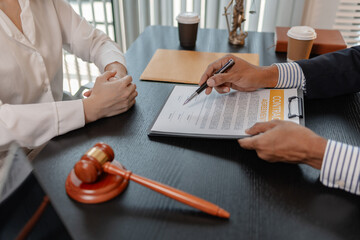 Professional legal consultation meeting between lawyer and client in office, discussing case...