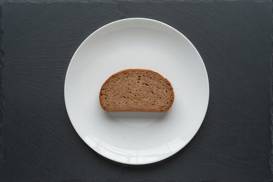 A slice of bread on a white plate against a dark background