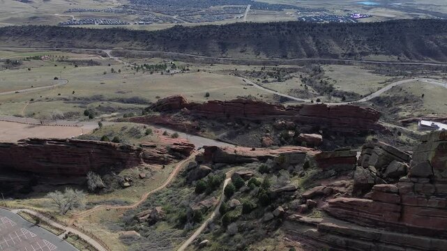 Sandstone valley panorama frames Red Rocks and Alameda Pkwy within hogback terrain overlooking eastern foothills. Warm sandstone faces mix with soft grasses under bright daylight in Morrison, CO
