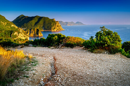 Gravel path on Mountainous Corfu Island during sunset, Gyali beach. Postcard landscape Greek coast from above