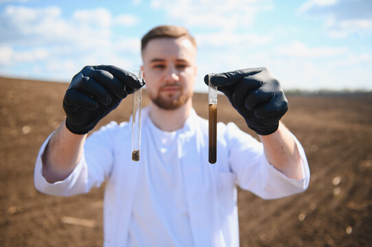 Agronomist holding soil samples in test tubes for analysis
