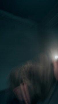 Vertical shot of young male hip hop dancer performing to camera in dark studio dynamic style with blurred motion trails, social media story format