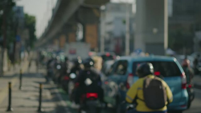 Many vehicles pass by in heavy traffic and are jammed on Jakarta's urban roads and bridges. Depicts traffic congestion, chaos and heavy pollution. Defocused and Blurred.