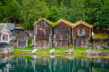 Fototapeta premium Old traditional houses on the coast of Geirangerfjord in town Geiranger, one of the most beautiful fjords in Norway