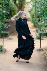 Naklejka premium Elegant dancer spinning. Refined woman performs graceful spin surrounded by vibrant plant life