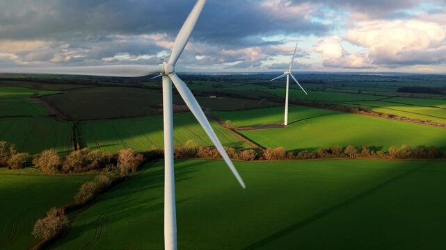 Drone view of renewable energy wind turbines in the green fields of Northamptonshire.