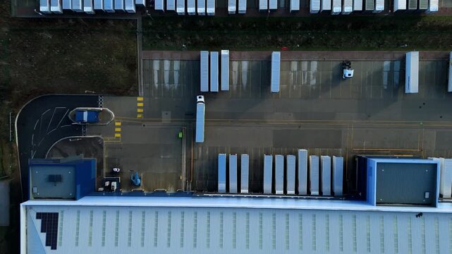 Top down aerial view of a semi-truck HGV reversing into a warehouse loading bay.