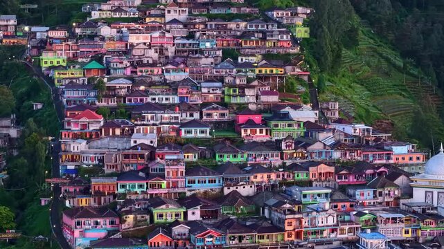 Blue hour aerial detail of Nepal van Java village, dense hillside homes with soft ambient lighting.