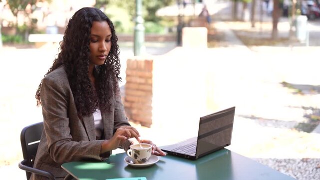 Young Woman Working on Laptop at Outdoor Caf