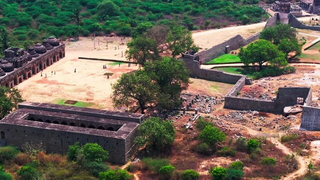 11 domed Elephant Stables with tourist, Guards House, Lotus Mahal and Shri Ranganatha Swami Temple at hampi, Kamalapura, Karnataka, india. day time, pan shot, drone shot, 4k.