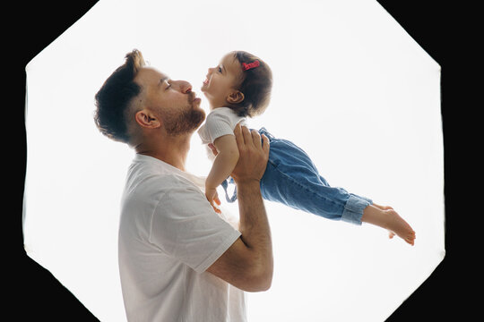  Father taking daughter in his arms in photo studio.