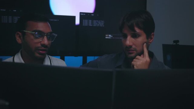 Software Developers Discussing AI Code On Computers In Tech Office Setting