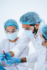 Fototapeta premium Scientist team wear protective mask and glove examine virus sample in test tube. Group of researcher work together for vaccine development, medical cure discovery and scientific epidemic prevention