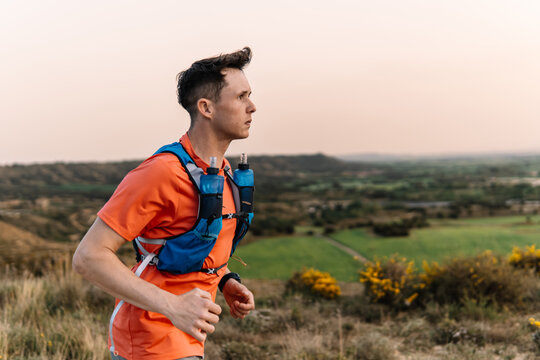 Trail runner with hydration vest training outdoors