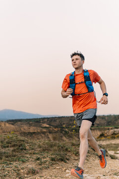 Trail runner training on dirt path outdoors