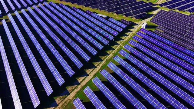 Edge-on bifacial tracker panels cast deep shadows creating bold alternating light-dark stripes. Parallel vertical solar tracker rows seen from directly above, Bulgaria