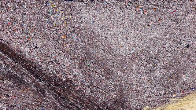 High resolution drone background completely filled with fragmented multicolored domestic consumer waste. Abstract texture of compressed plastic refuse