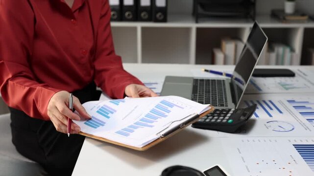 Businesswoman analyzing financial statistics and data analysis for company growth, checking paperwork with charts and graphs, marketing strategy and corporate planning