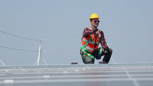 Electricians install solar panels outdoors in bright sunlight, checking the solar panel installation on the roof shopping mall in the city to save on electricity costs and provide renewable energy wit