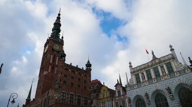 Static shot of the town hall and Artus Court. Branch of the Gdańsk Museum, with clouds passing over. Gdansk, Poland.