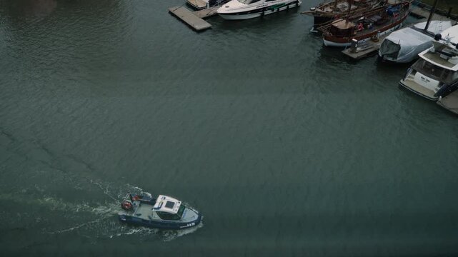 A police boat patrolling the marina, seen through the window of a building, Gdansk, Poland.