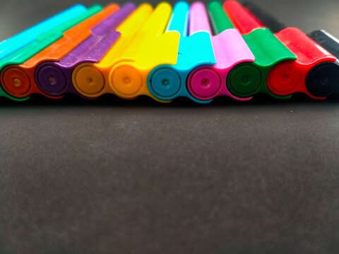 Multicolored Marker Row Isolated Against Black Background