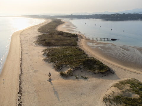 Early morning aerial view of El Puntal spit stretching into the distance with its empty sandy beach. Somo, Cantabria, Spain.