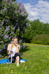 Obraz premium Smiling middle aged woman blogger recording video on smartphone in park.