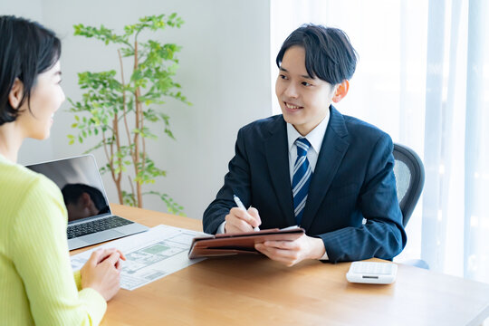 聞き取りをする不動産営業マンと女性