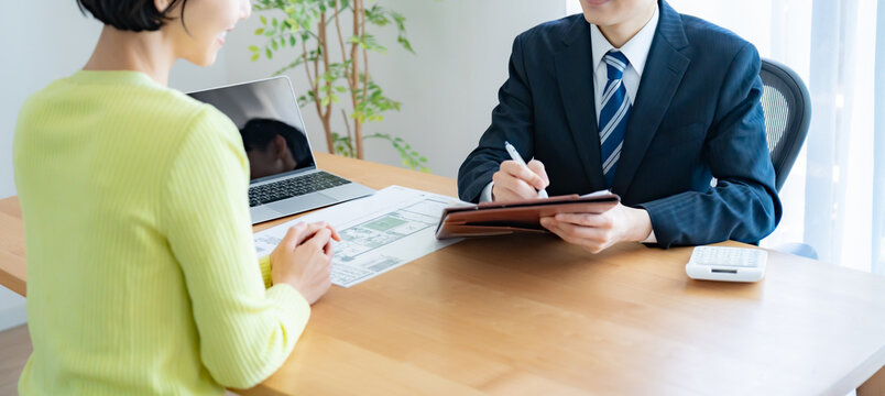 聞き取りをする不動産営業マンと女性
