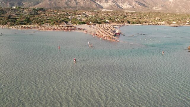 Aerial view of exotic Balos lagoon with sandspit and beach umbrellas