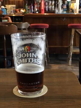 glass of John Smiths beer on a pub table