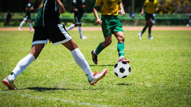 Professional soccer players competing during an intense outdoor match on grass pitch