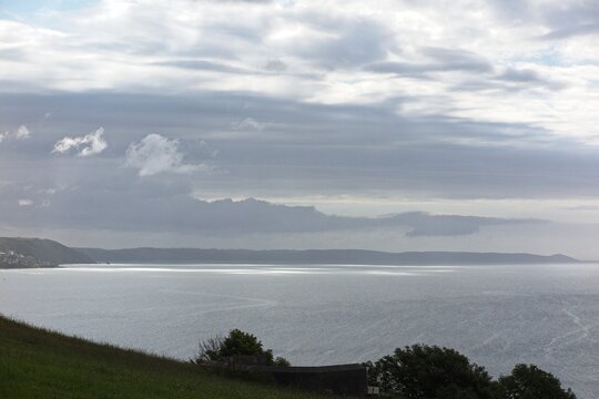 Dark moody clouds over Whitsand bay from Looe Cornwall