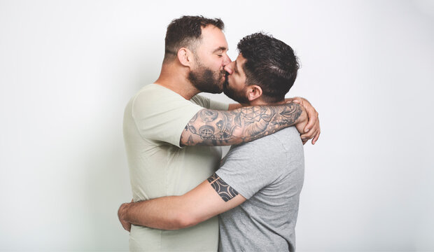 Young homosexuals gay couple love each other on a white background.
