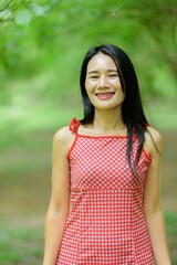 Fototapeta premium Woman in Red Dress Enjoying Nature in Beautiful Flower Garden