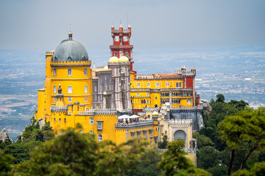 Historic Pena Palace in Sintra, Portugal, viewed from lush foreground foliage