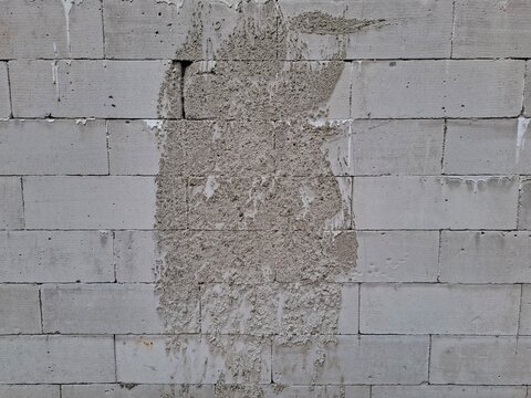 8Lightweight concrete block wall with rough splattered cement mortar texture.