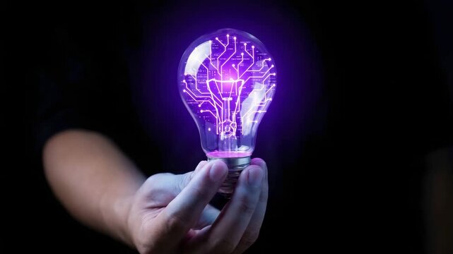 A glowing light bulb with circuit board patterns held in hand for the concept of technology and innovation.