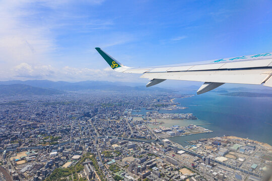 Fukuoka, Japan - May 26, 2026: An aerial view of the densely populated Fukuoka cityscape and buildings from a window seat of a Spring Airlines Airbus A320 just after takeoff.