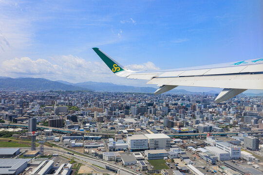 Fukuoka, Japan - May 26, 2026: An aerial view of the densely populated Fukuoka cityscape and buildings from a window seat of a Spring Airlines Airbus A320 just after takeoff.