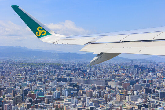 Fukuoka, Japan - May 26, 2026: An aerial view of the densely populated Fukuoka cityscape and buildings from a window seat of a Spring Airlines Airbus A320 just after takeoff.