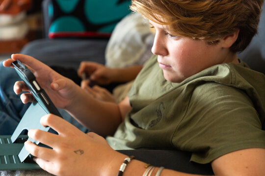 12 year old boy using tablet computer for gaming
