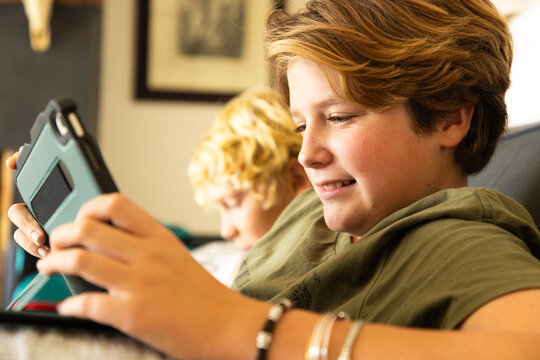 12 year old boy using tablet computer for gaming