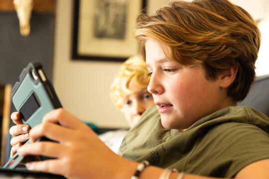 12 year old boy using tablet computer for gaming