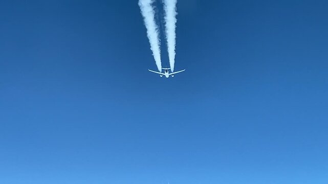 A spectacular pilot point of view of an airliner passing from above.