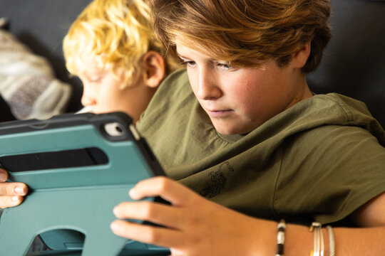 12 year old boy using tablet computer for gaming